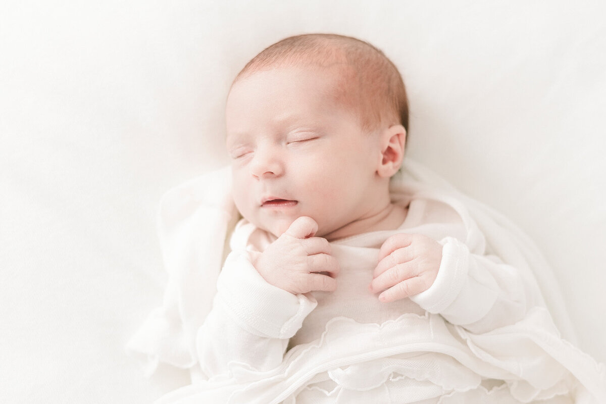 Sleeping newborn in white wrap