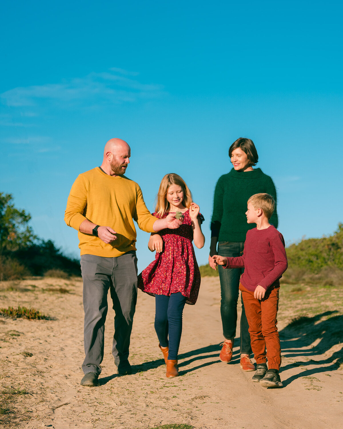 Family walking together on a trail in Marin County during golden hour – captured by Marin family photographer Isela Lozano