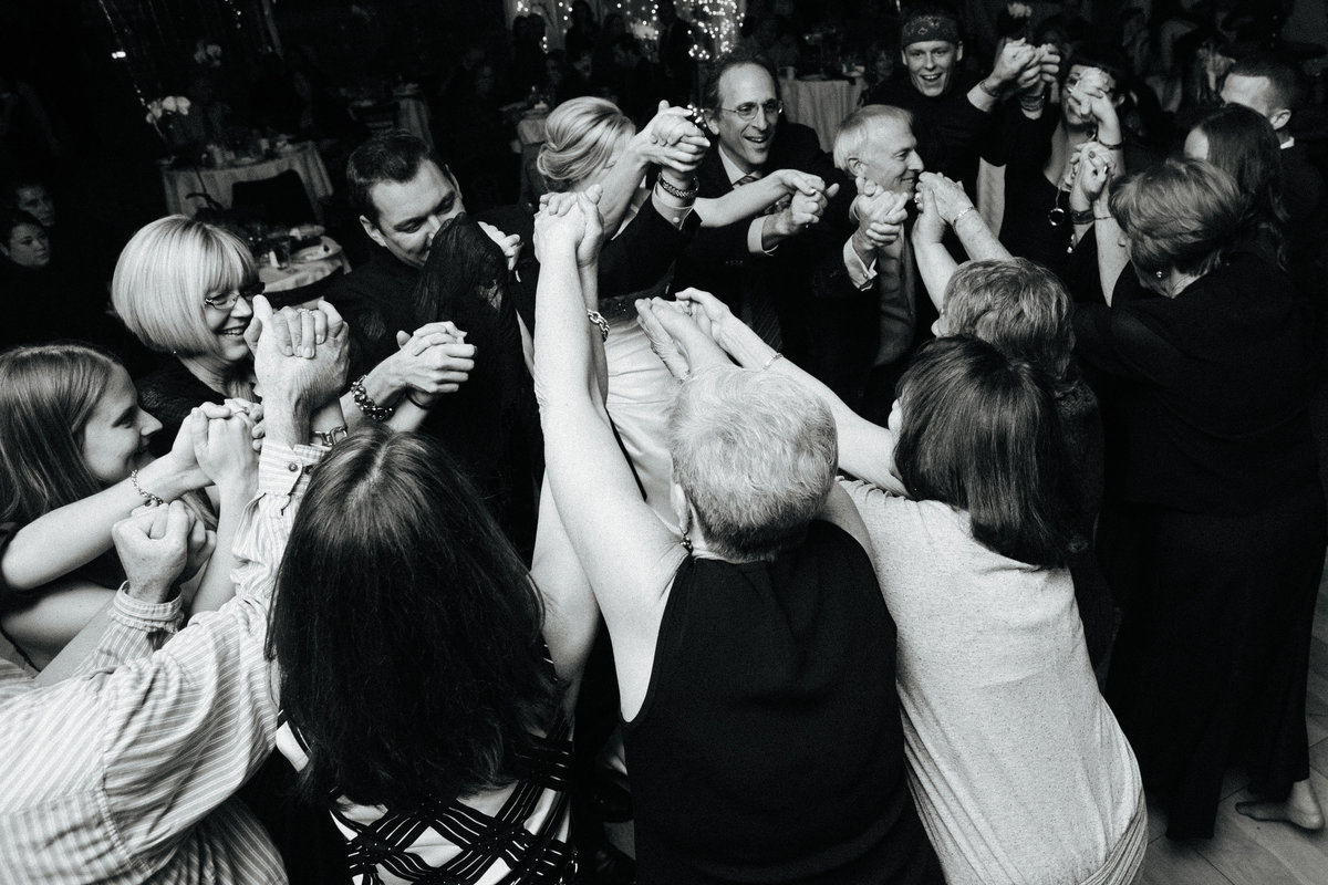 wedding guests holding hands at jewish wedding reception