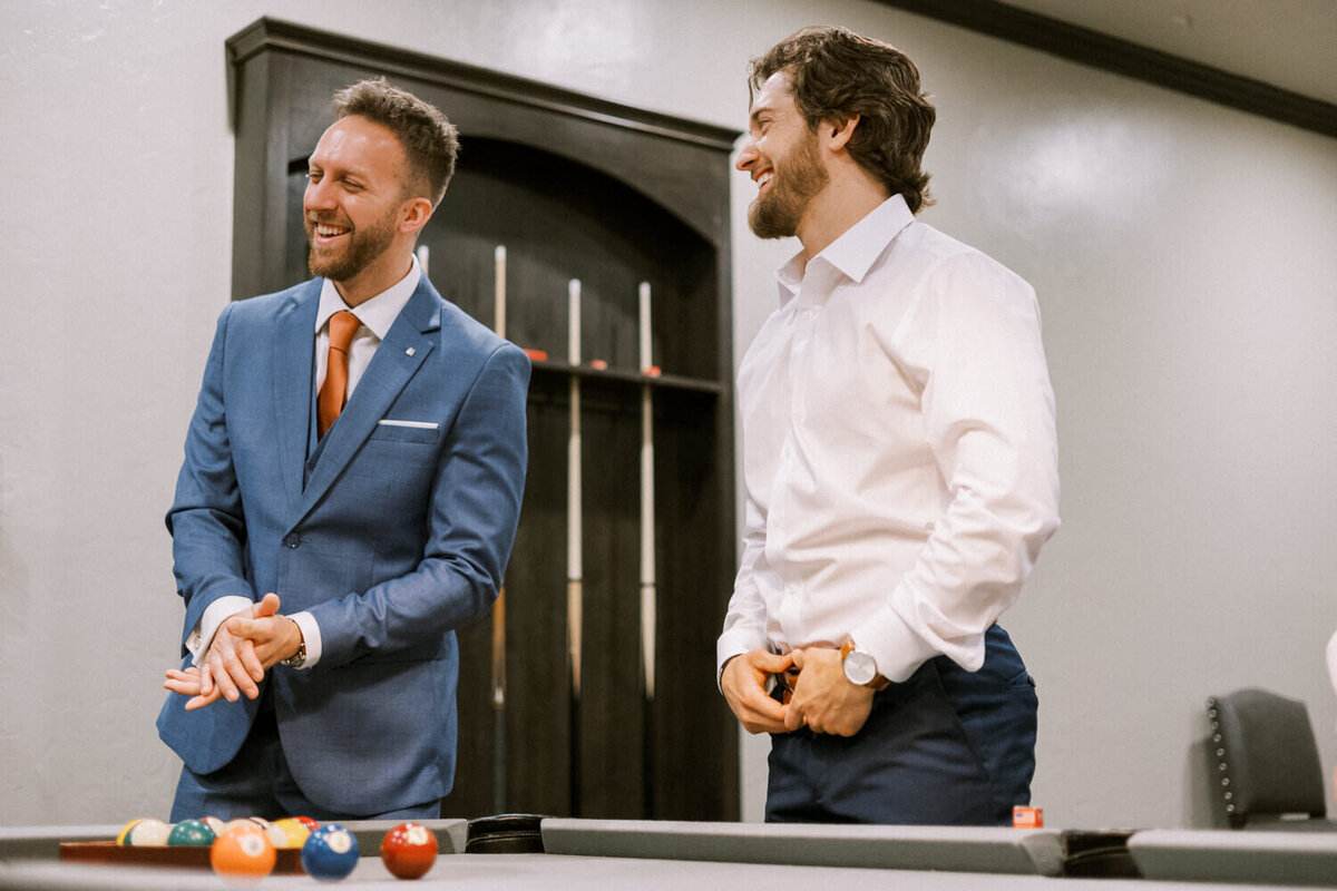 two-men-laughing-together-while-getting-ready