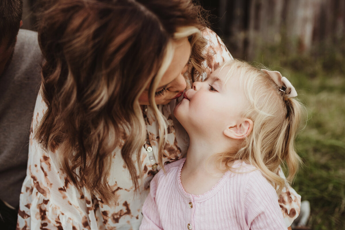 Mom leans down to kiss her daughter.
