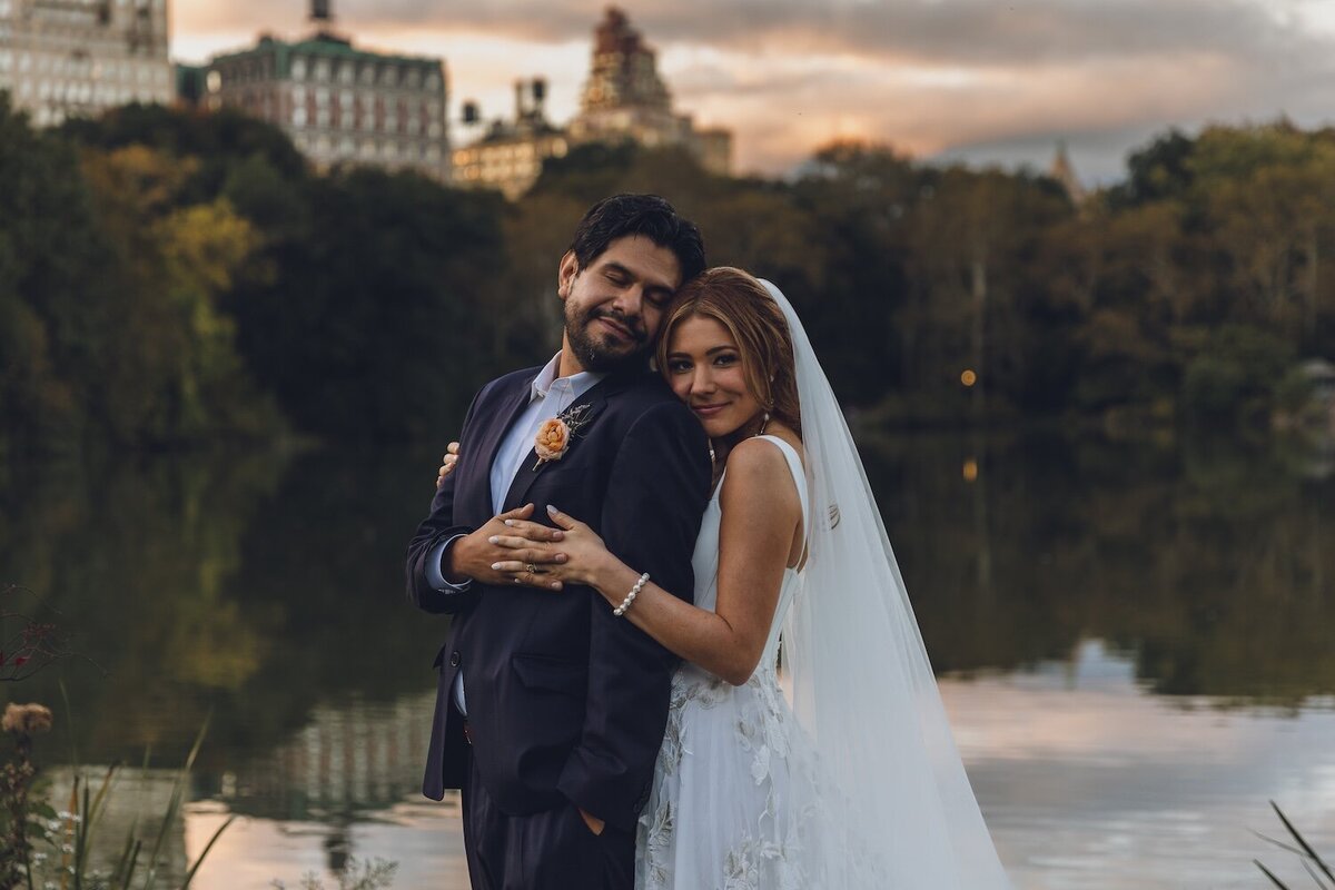 Sunset portrait of bride and groom beside the lake