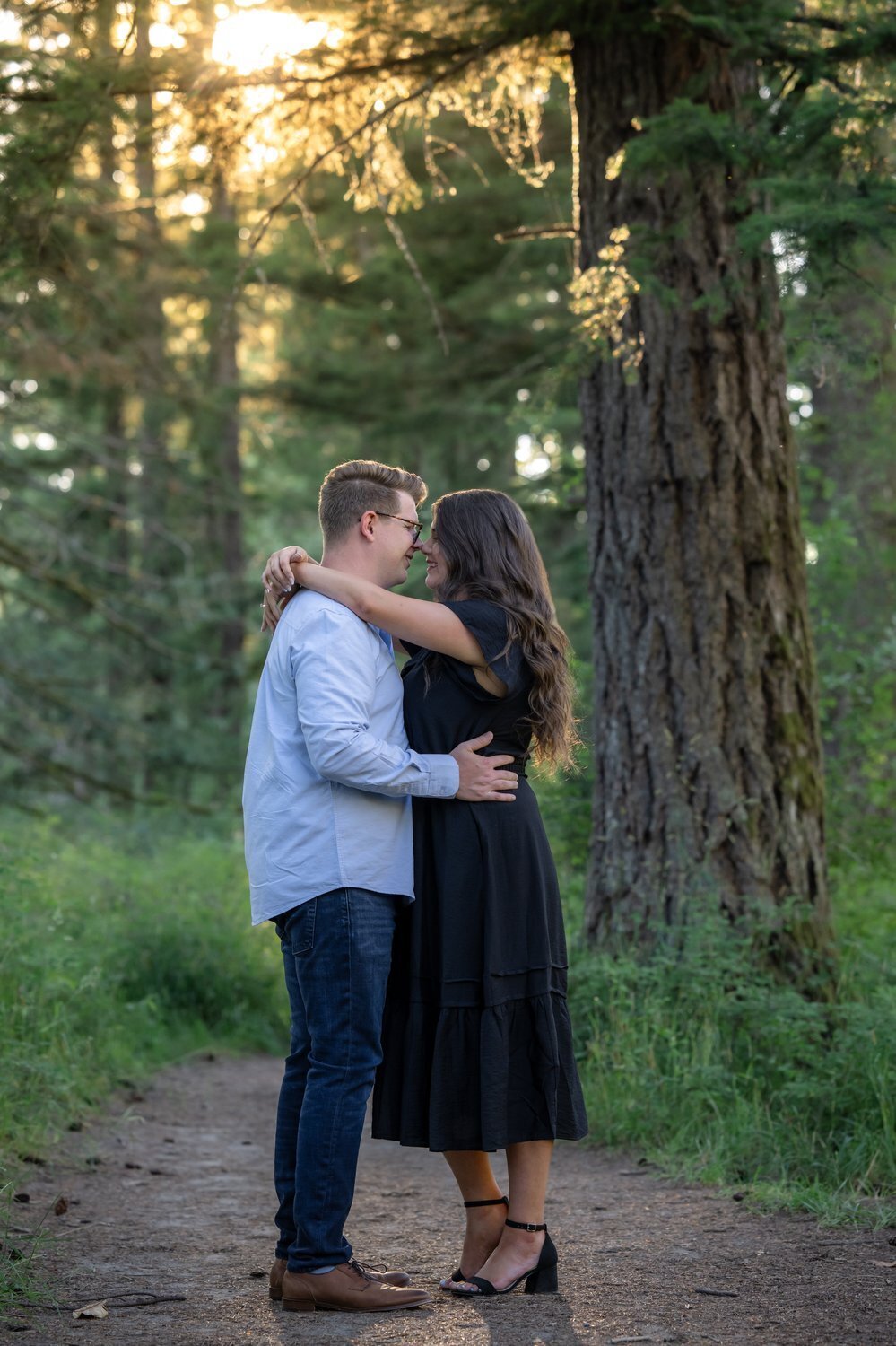 engagement couple washington forest trail hugging