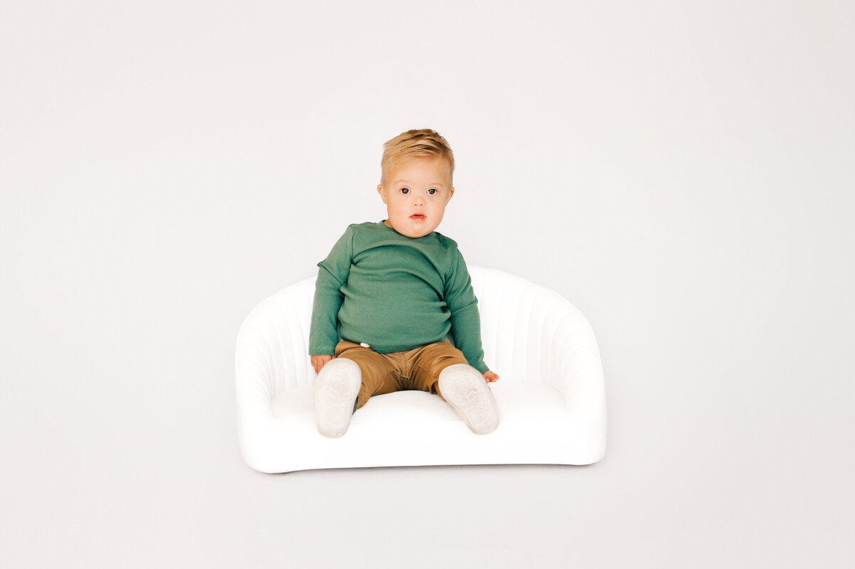 toddler boy sitting on couch during Springfield MO 1st birthday photography session