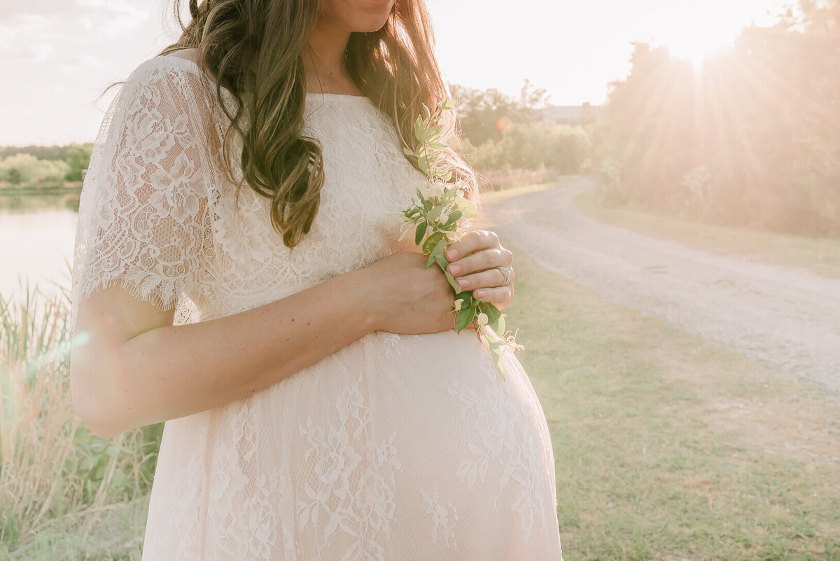 pregnant woman holding flowers for a picture