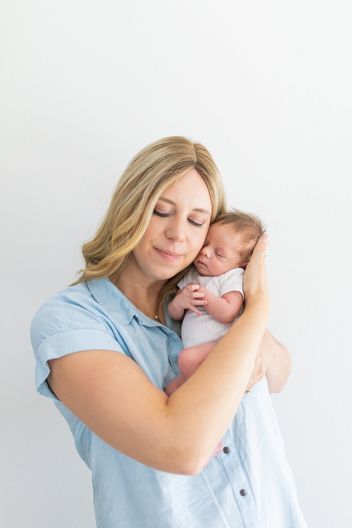 Mom holding newborn baby in home in Rancho Sante Fe.