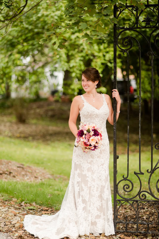 bride posing with iron gates at the Hyeholde restaurant wedding venue