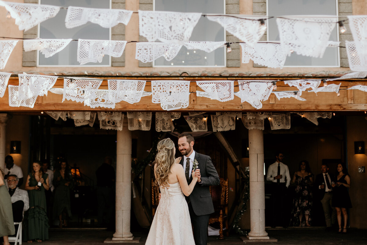 bride and grooms first dance in an outdoor courtyard