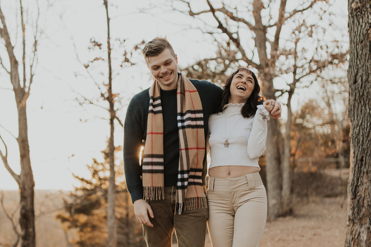 fall couples photoshoot, linked arms laughing