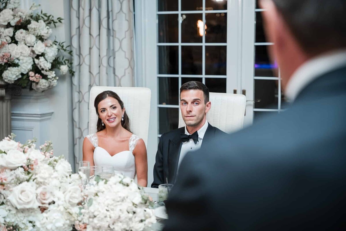 Bride and groom listening to the speech of the father of the bride captured by Orlando Wedding Photographer