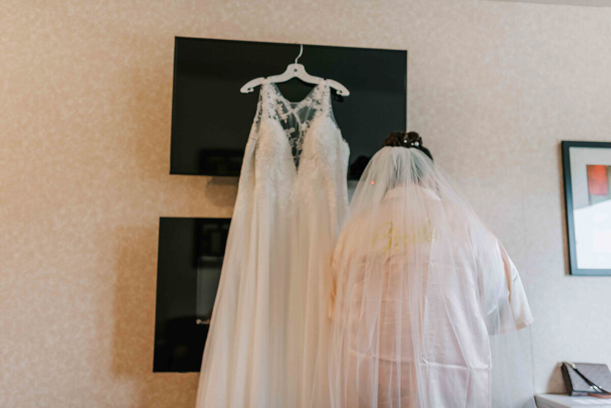 Bride standing with her dress while getting ready.