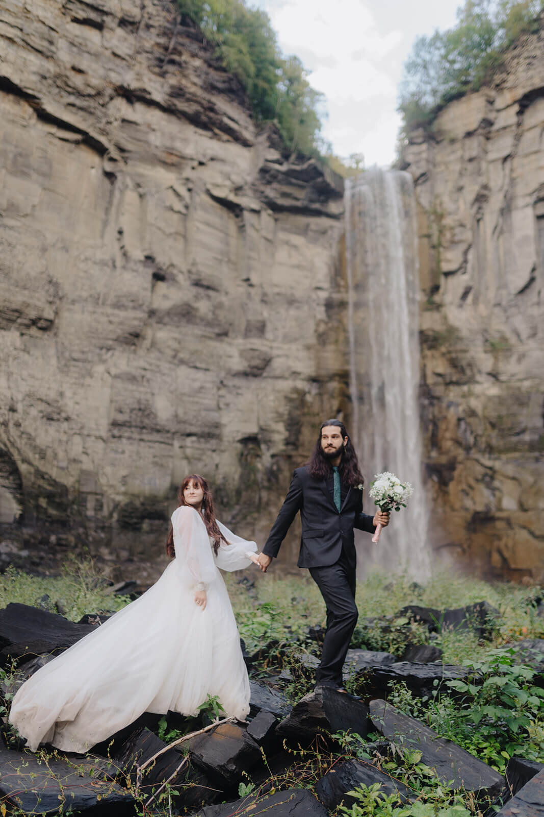 Bride and groom in front of a waterfall