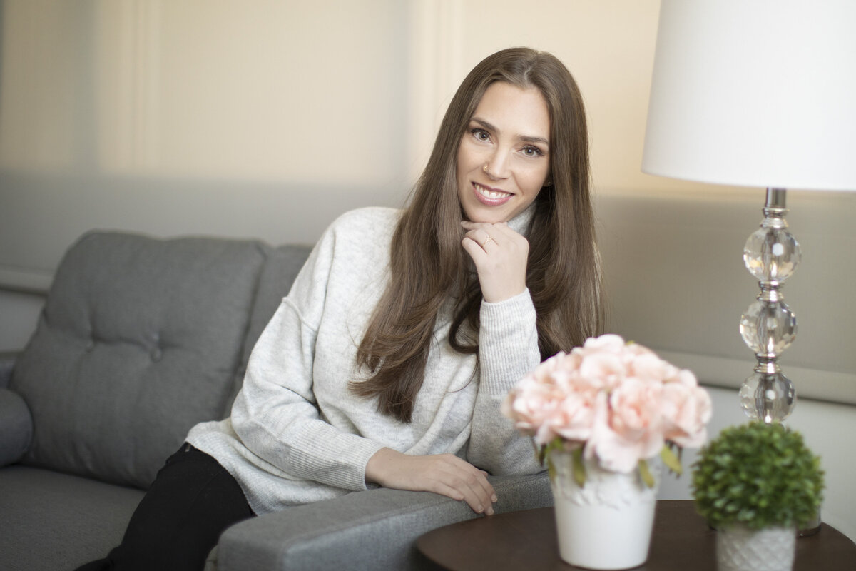 girl sitting couch therapist pink roses headshot