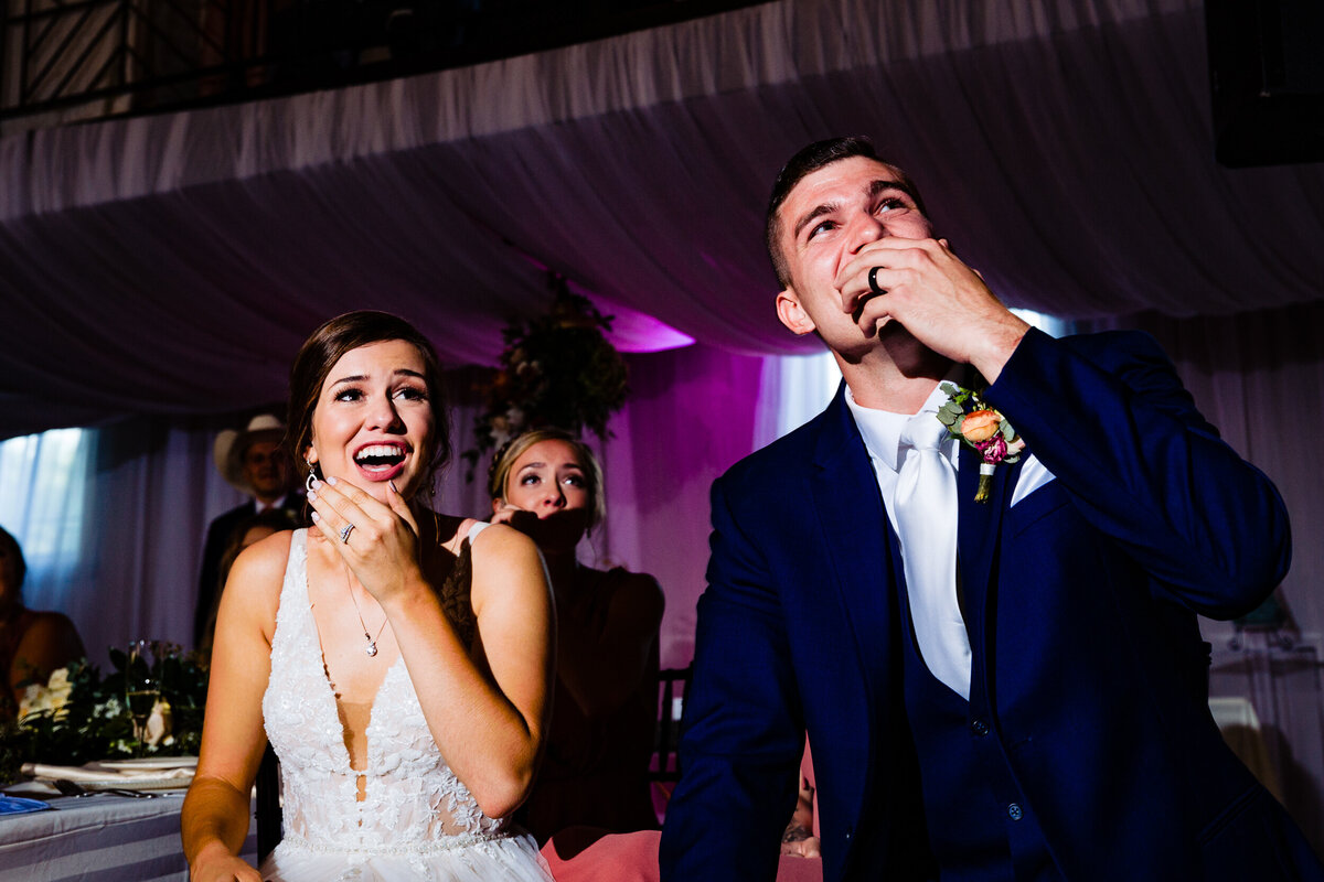 One of the top wedding photos of 2020. Taken by Adore Wedding Photography- Toledo, Ohio Wedding Photographers. This photo is of a bride and groom lauching during the wedding reception speeches at Nazareth hall in TOledo Ohio