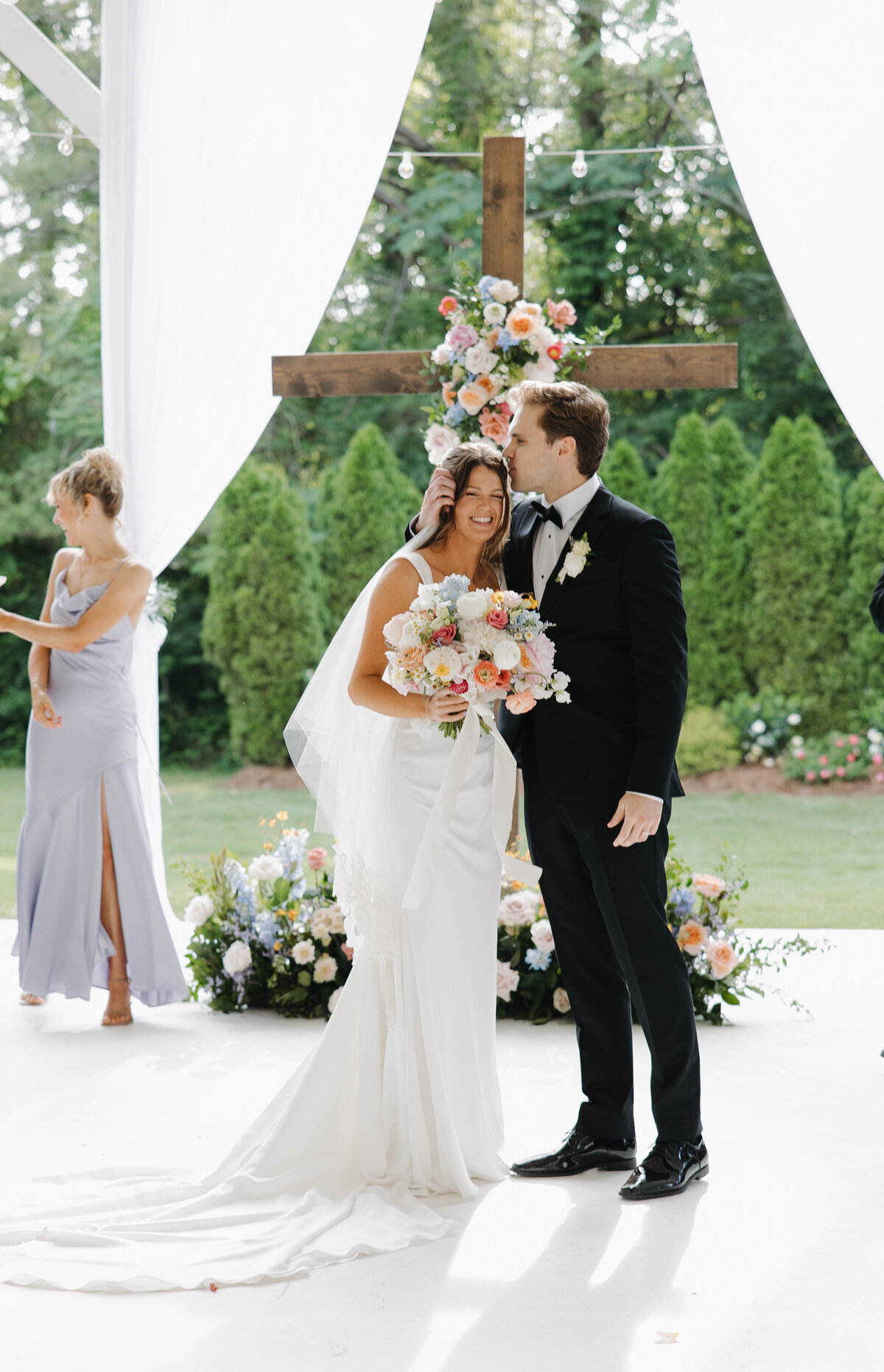 Groom kissing Brides head after saying 'I Do' at their Camelot manor wedding
