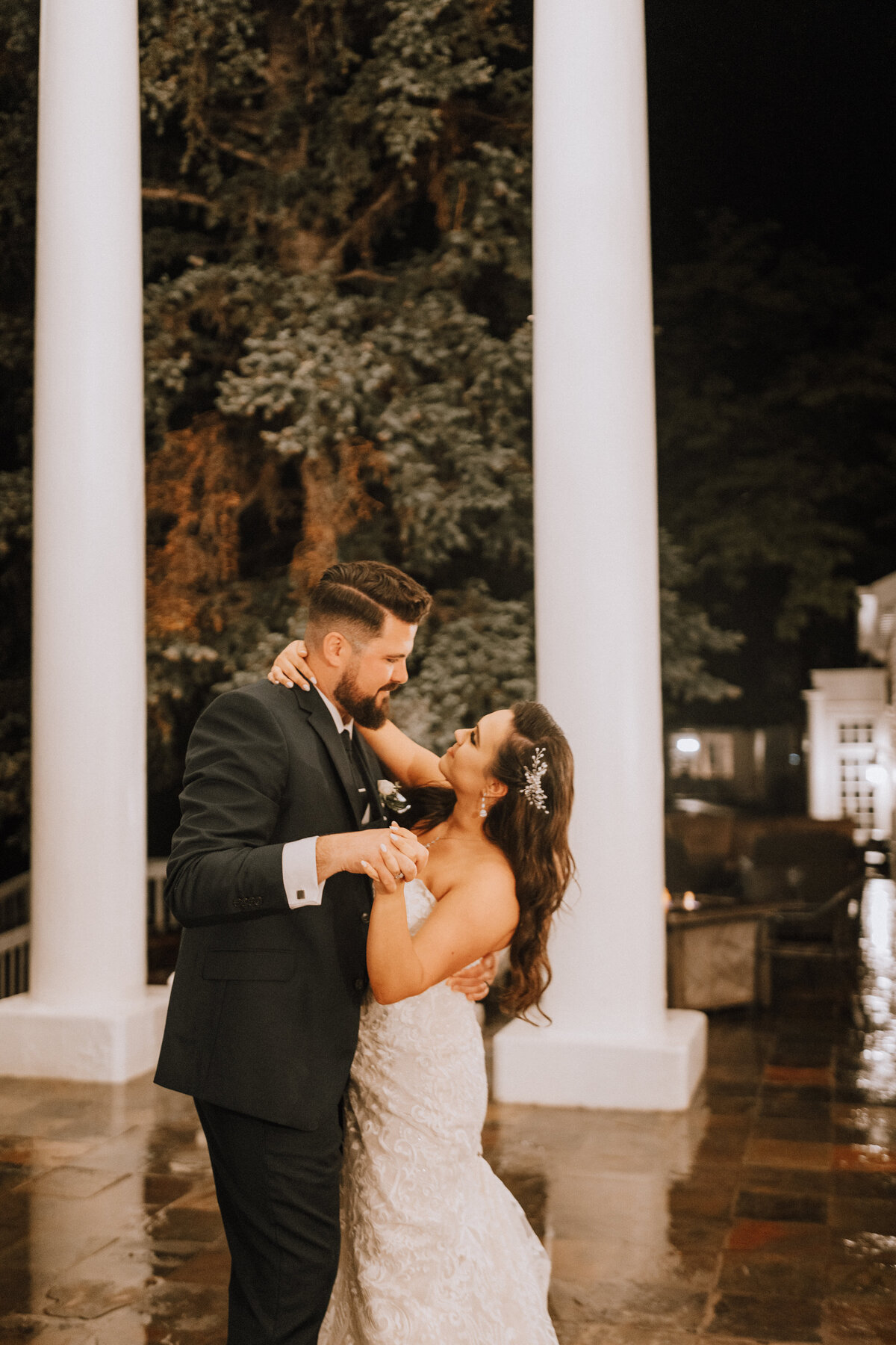 bride and groom dancing in the rain at the manor house