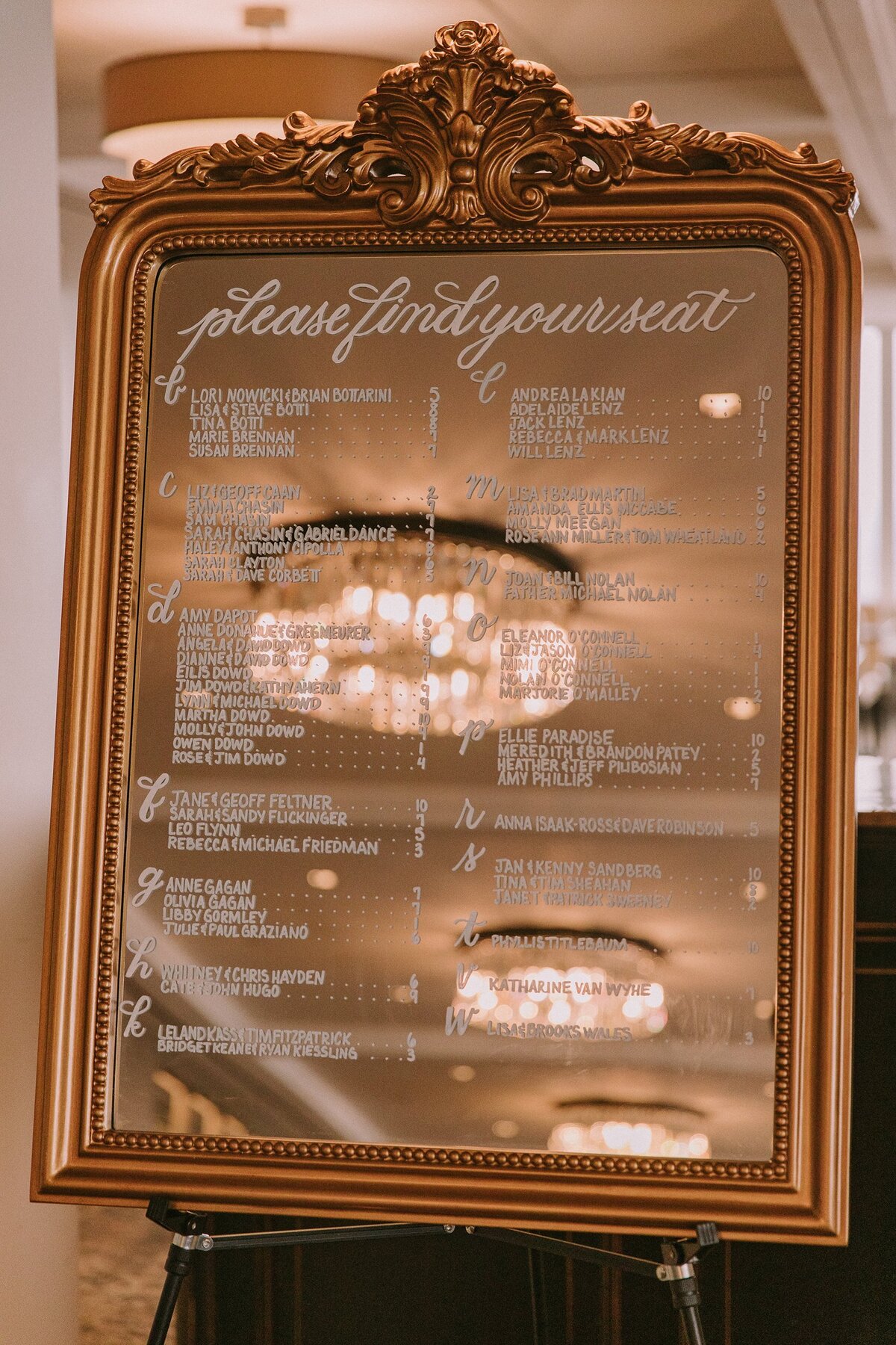 Medium vertical mirror with ornate ornament on top with calligraphy for seating chart