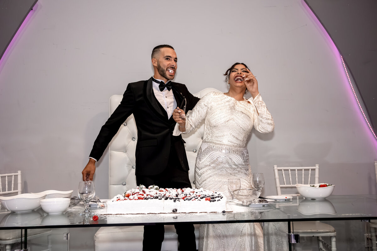 Bride and Groom Laughing Together During Wedding Cake Cutting – Los Angeles Arabic Wedding Photography