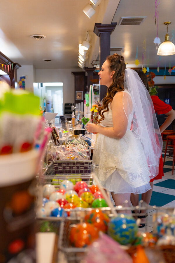 Bride ordering candy at a candy store.