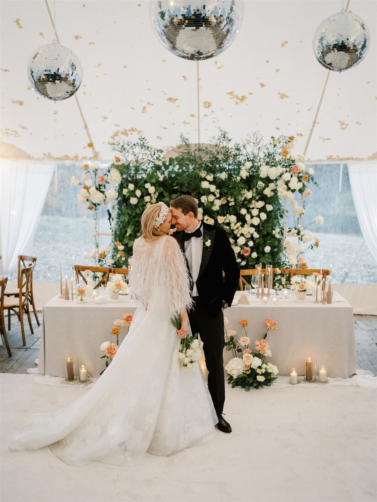 Wedding couple in tent with flower wall