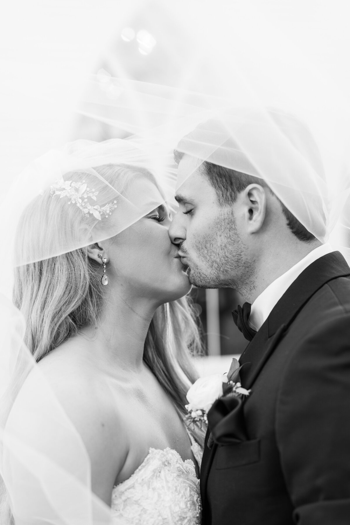 Black and white of Bride and Groom kissing under the veil after wedding at the Springs Wallisville