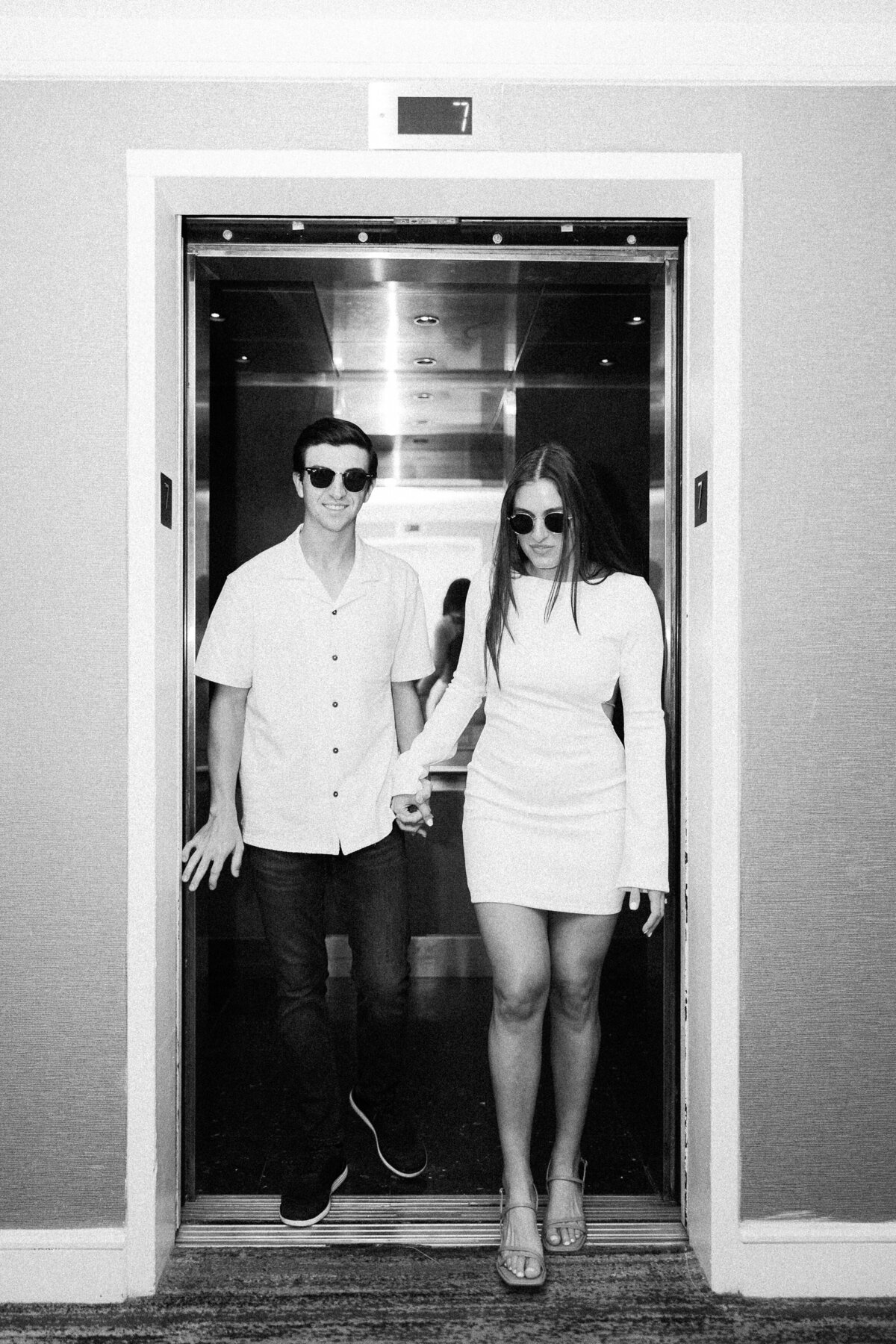 Couple exiting an elevator, photographed by Miami wedding photographer Claudia Amalia, showcasing her wedding and lifestyle photography services.