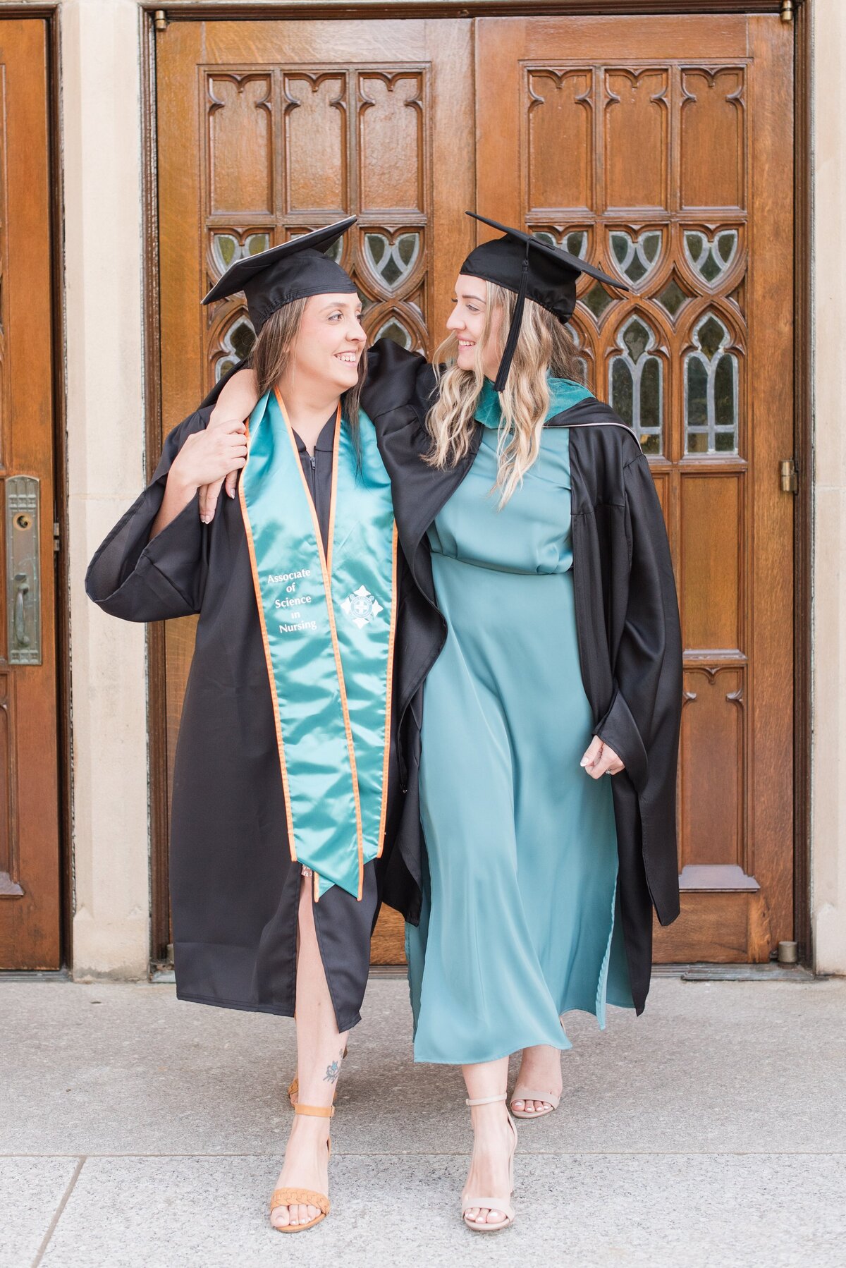 graduate sisters embracing