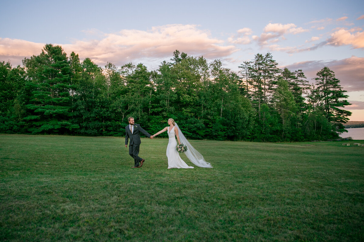 Bride and Groom walking on grass | Taken By Wedding Photographer at Grace on the Lake