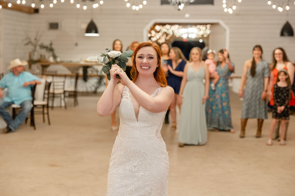 bride tosses bouquet at wedding in Boerne Texas string lights