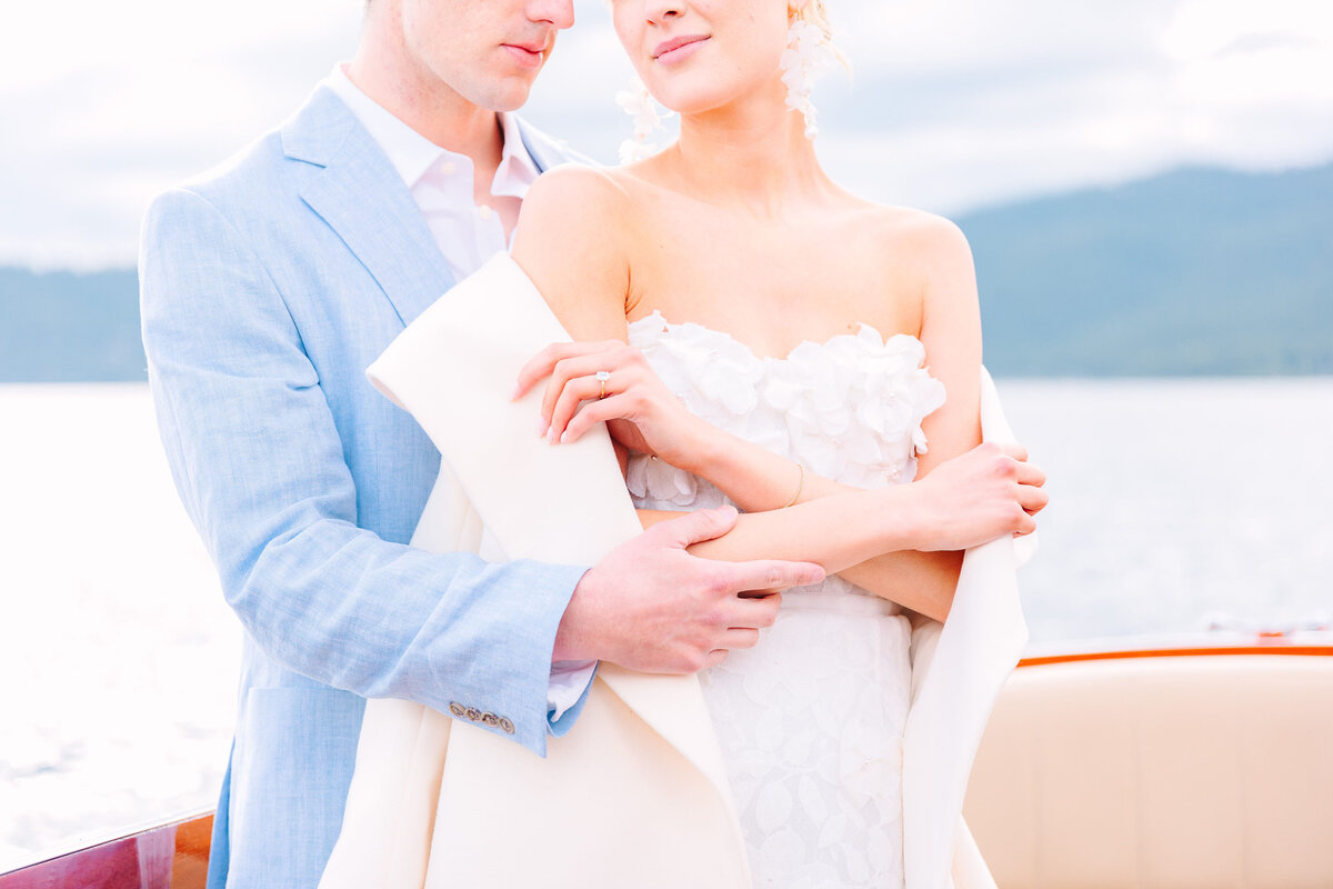 Bride, groom, and wedding party sit at wedding reception overlooking Lake Tahoe