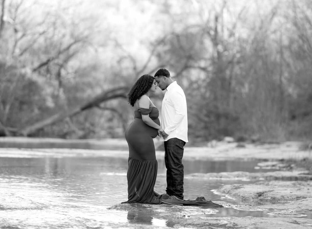 couple embracing by a creek