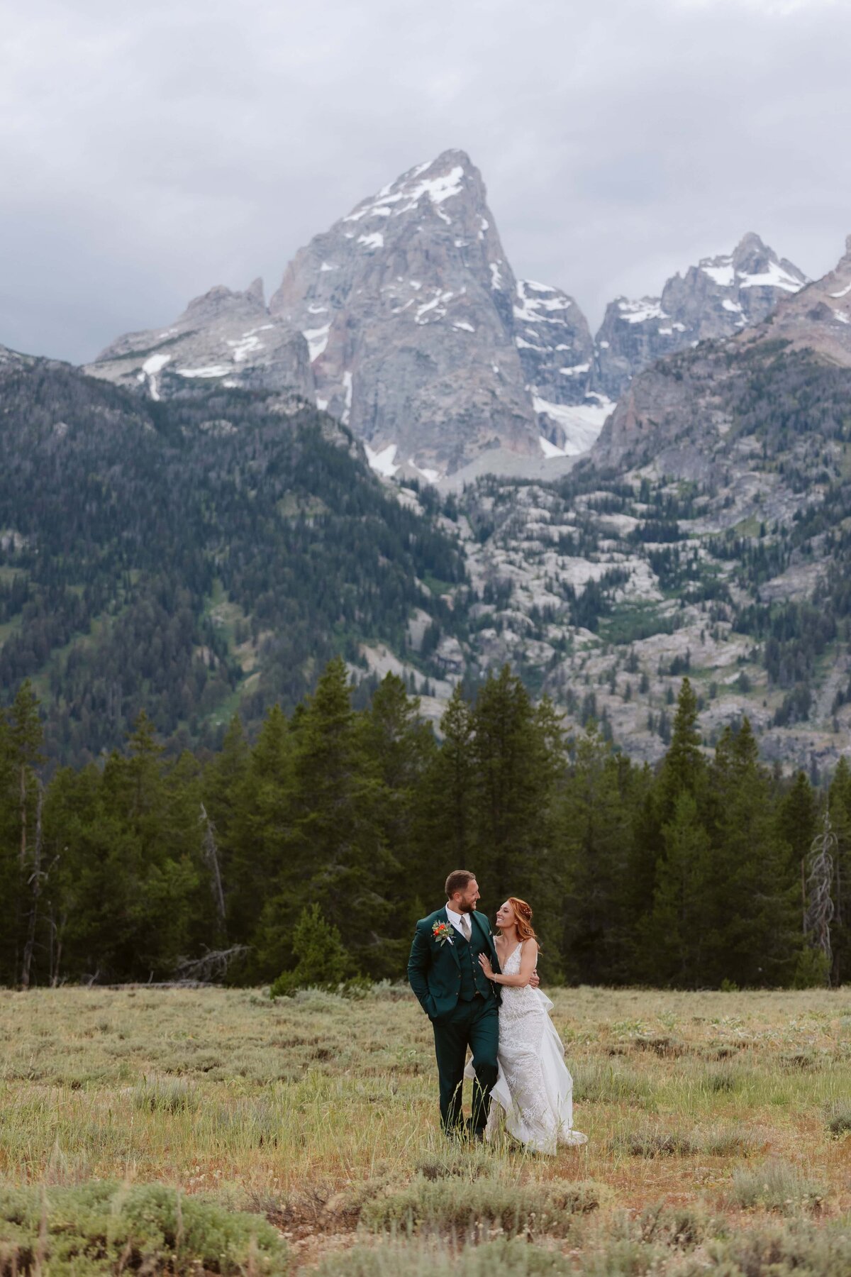 couple that just got married walking around in front of the grand teton