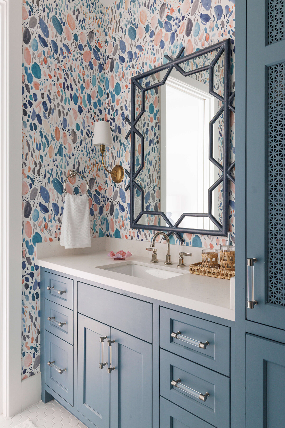 oyster creek studios missouri city new build blue vanity with watercolor pattern wallpaper and geometric black mirror in bathroom