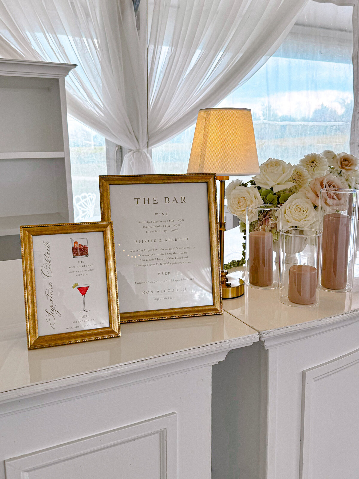 Custom Watercolour Signature Cocktail and Bar Sign in Gold Frames on a white bar with pink candles and flowers