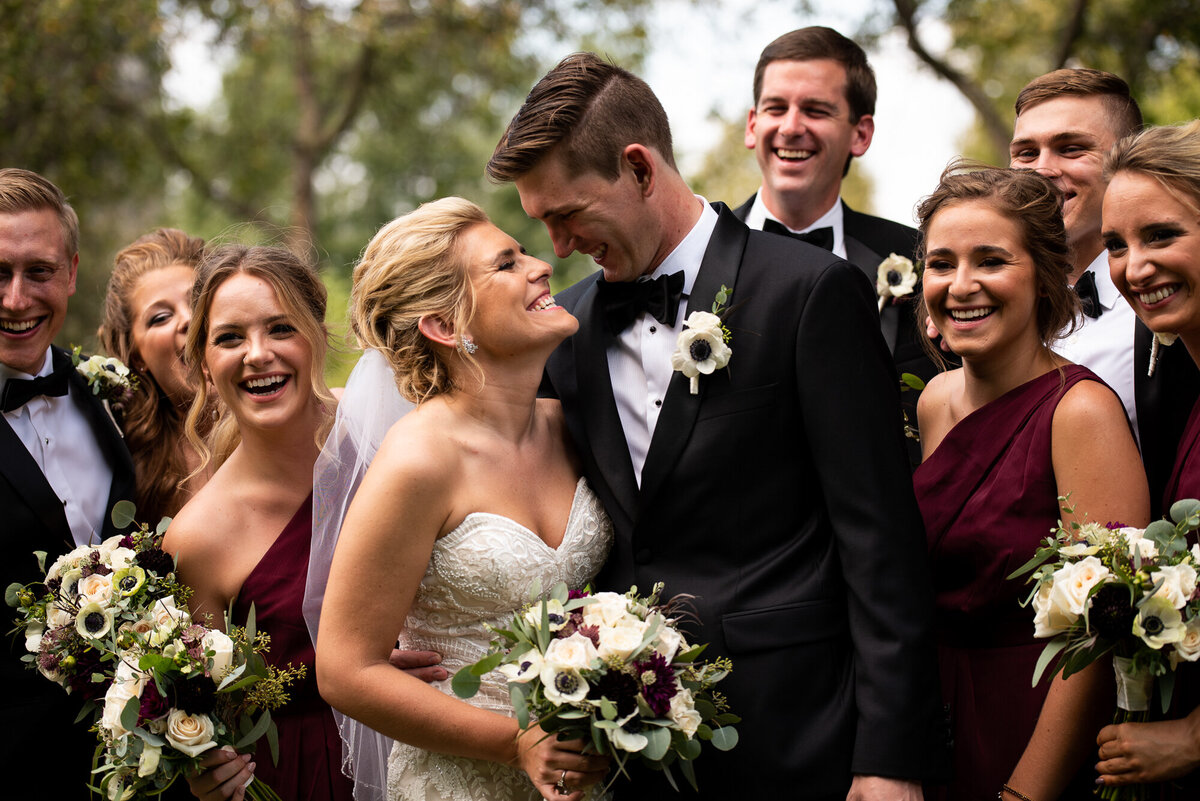 Wedding party huddles around bride and groom for a portrait