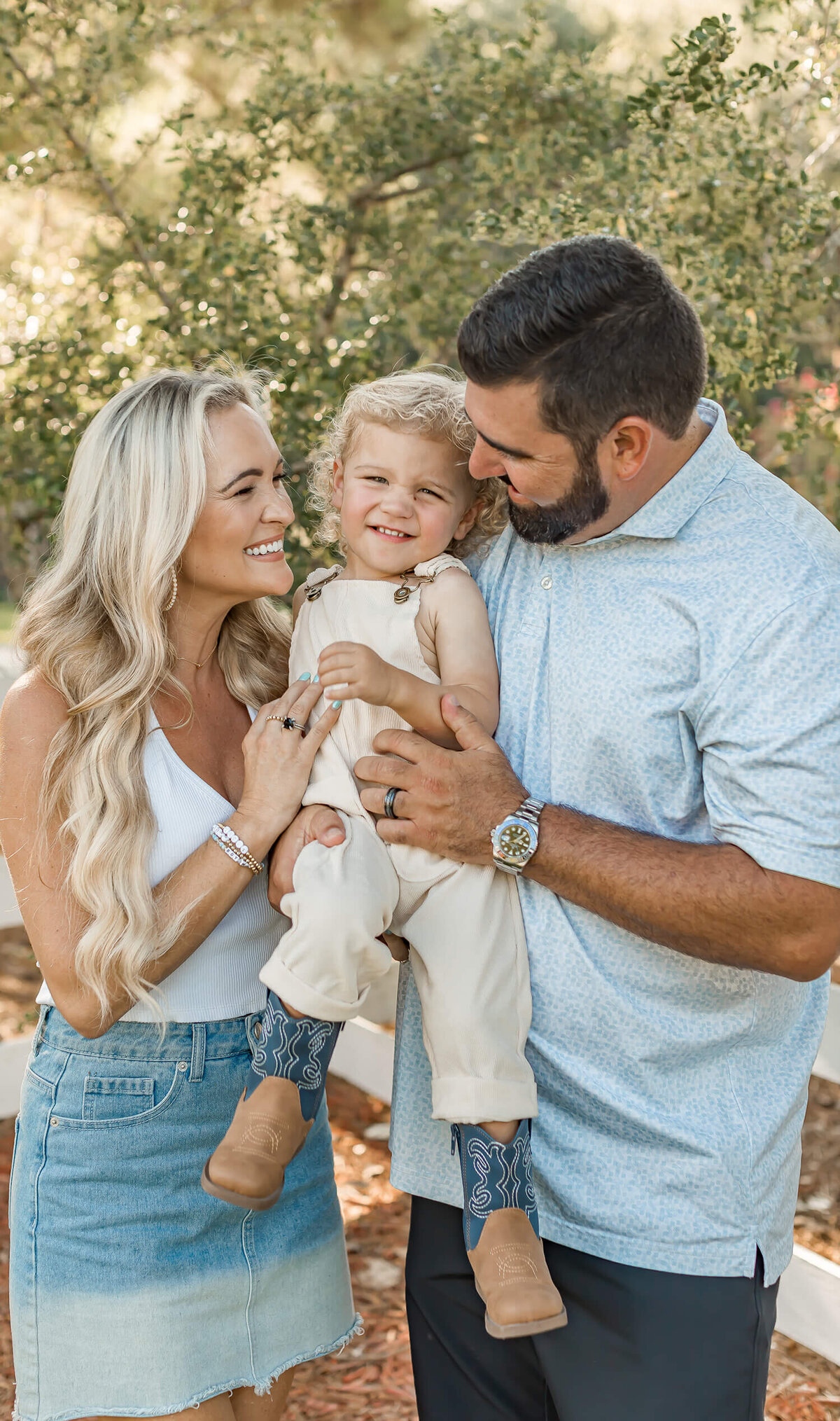 A mother and father hold their child close in a heartfelt, candid moment, capturing the beauty of authentic parenthood and genuine family connection.