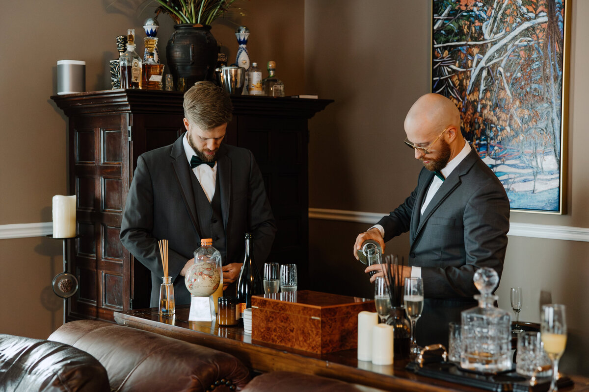 The groomsmen busy making drinks at the bar of the groom's waiting room