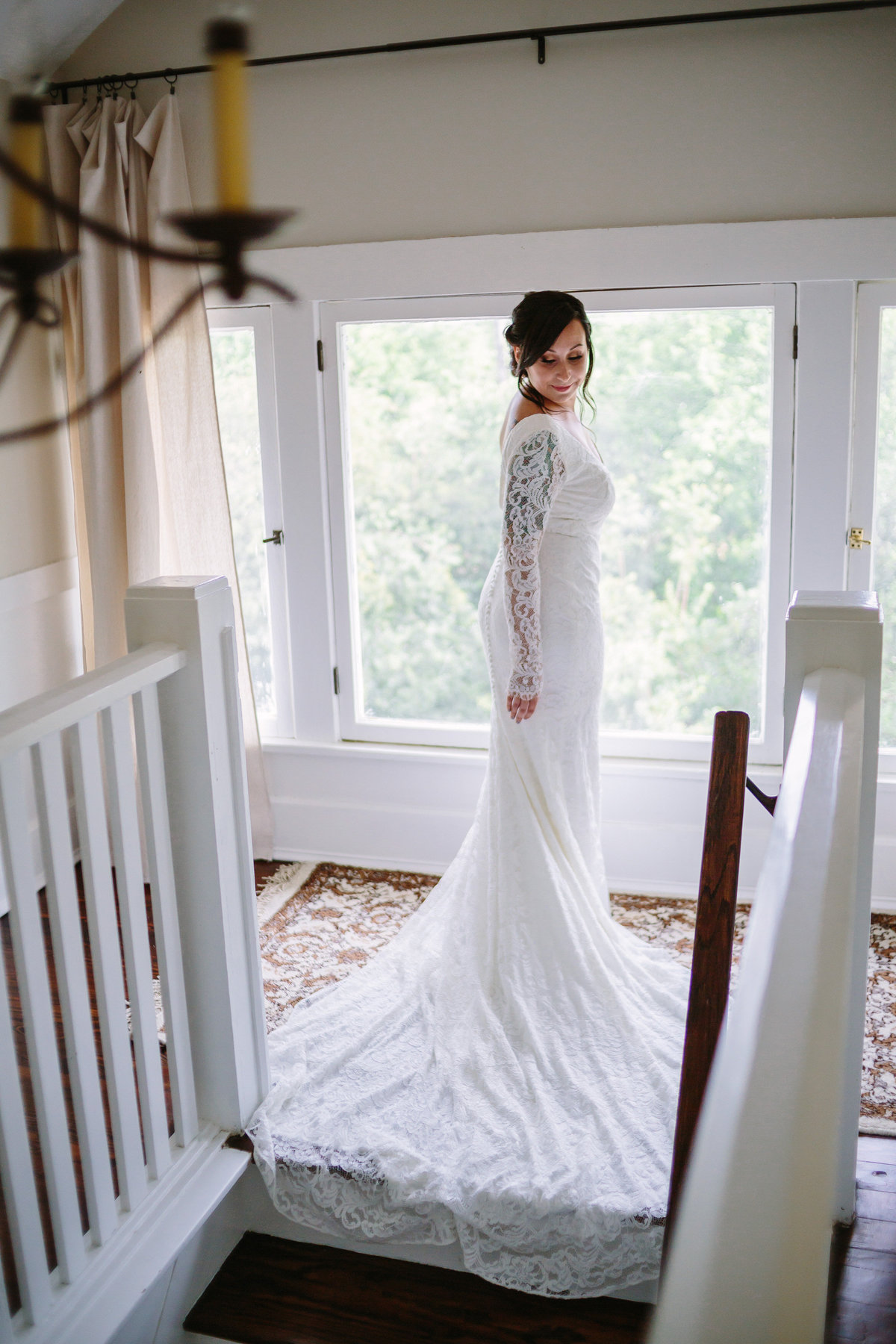 bride at top of stairs at an airbnb rental for getting ready before her wedding