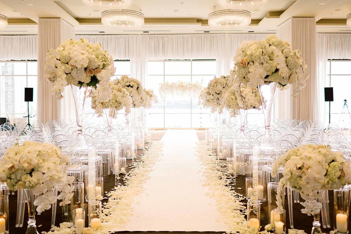 Four Seasons wedding ceremony aisle lined with white flowers and candles