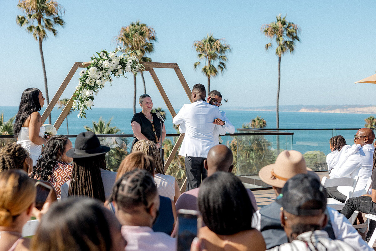 Groom hugging man at San Diego wedding