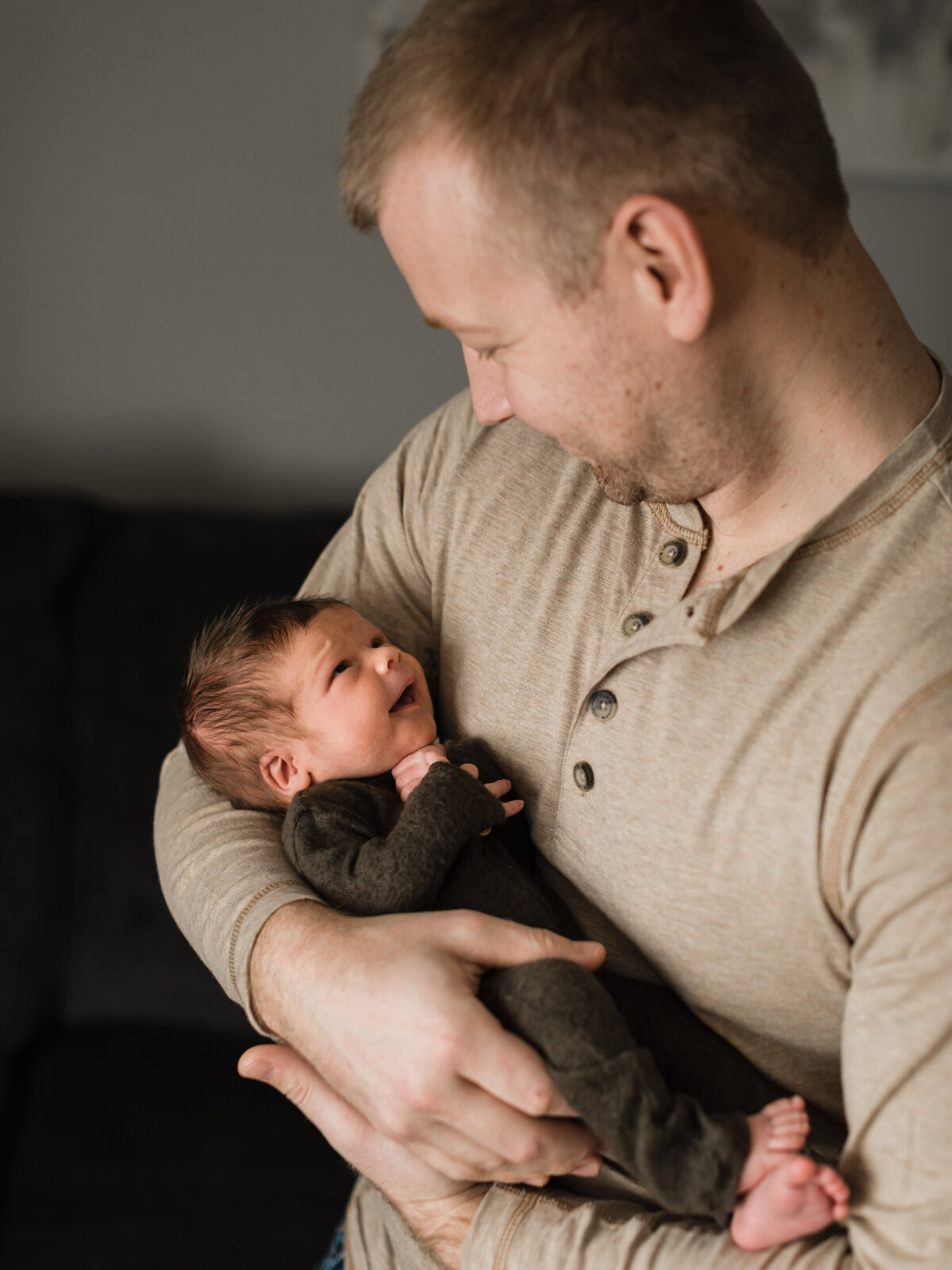 dad holding newborn son for in home lifestyle session cleveland newborn photographer
