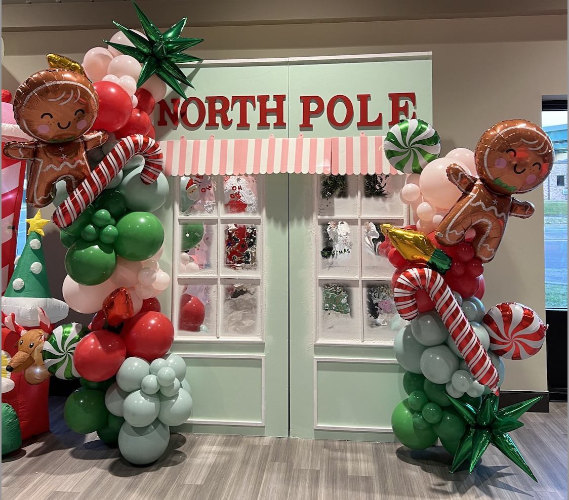North Pole backdrop styled with festive balloons and gingerbread decorations from the LUXE collection