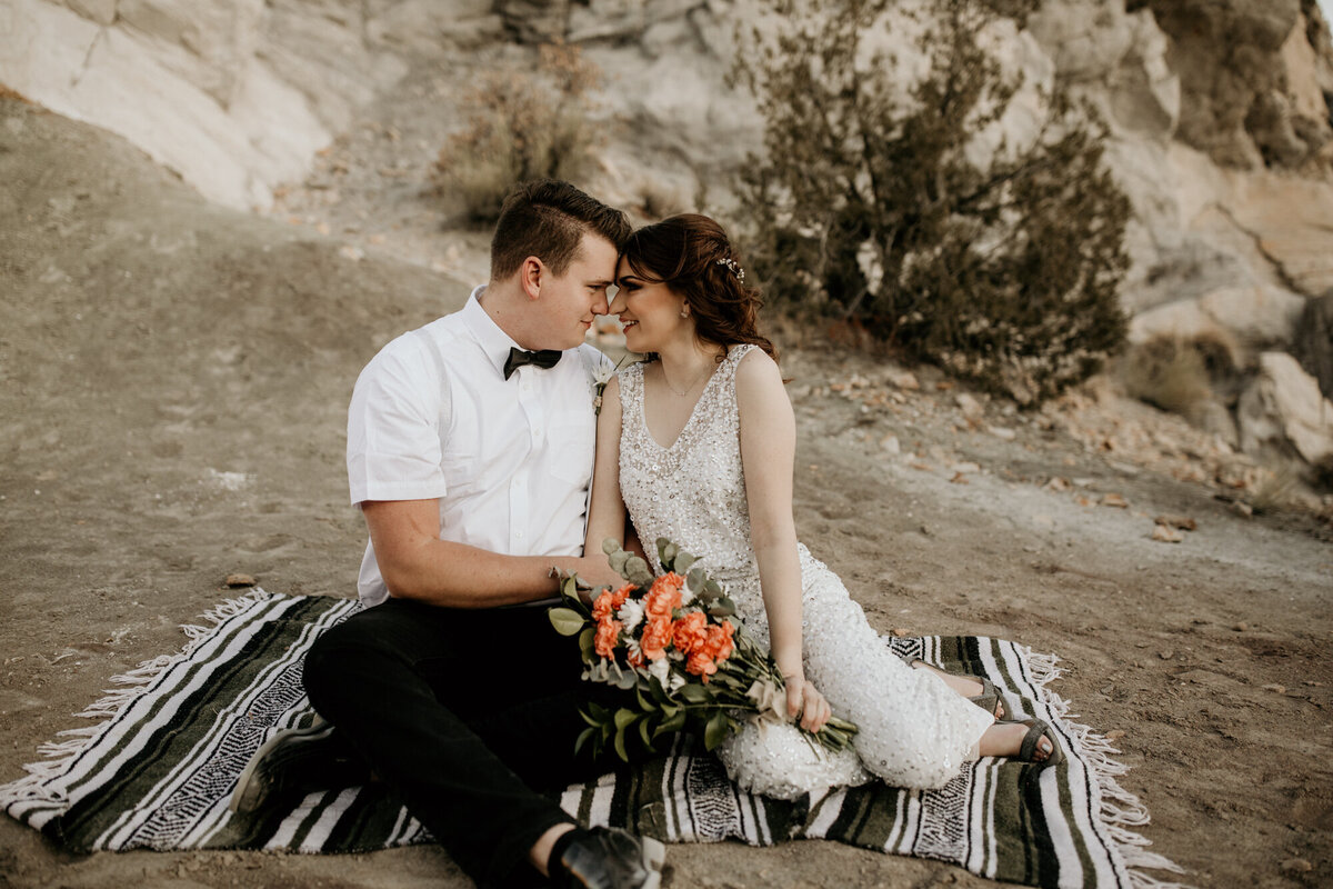 Bride and groom sitting on a blanket together in Albuquerque