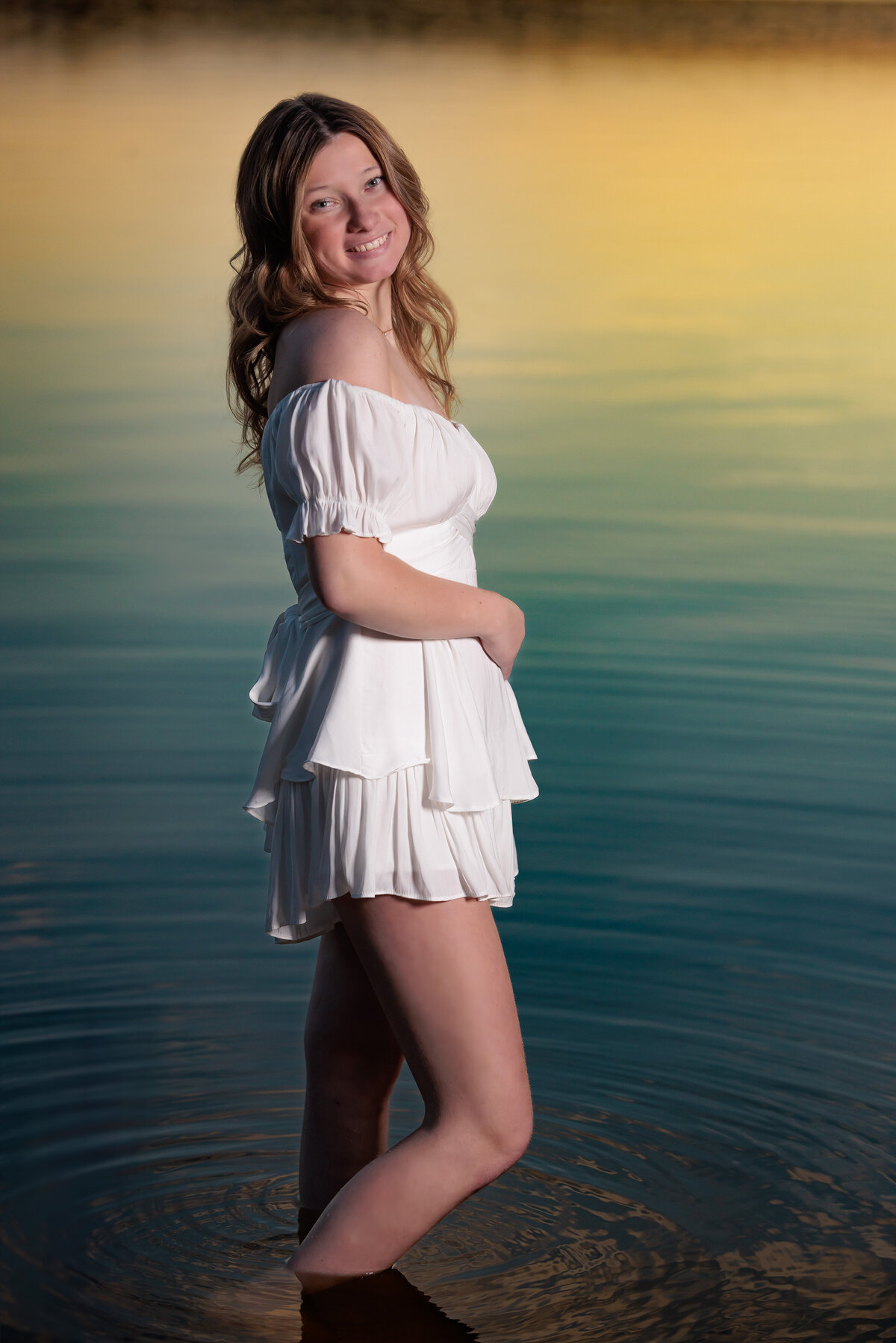 Raleigh senior at sunset in a lake with reflections