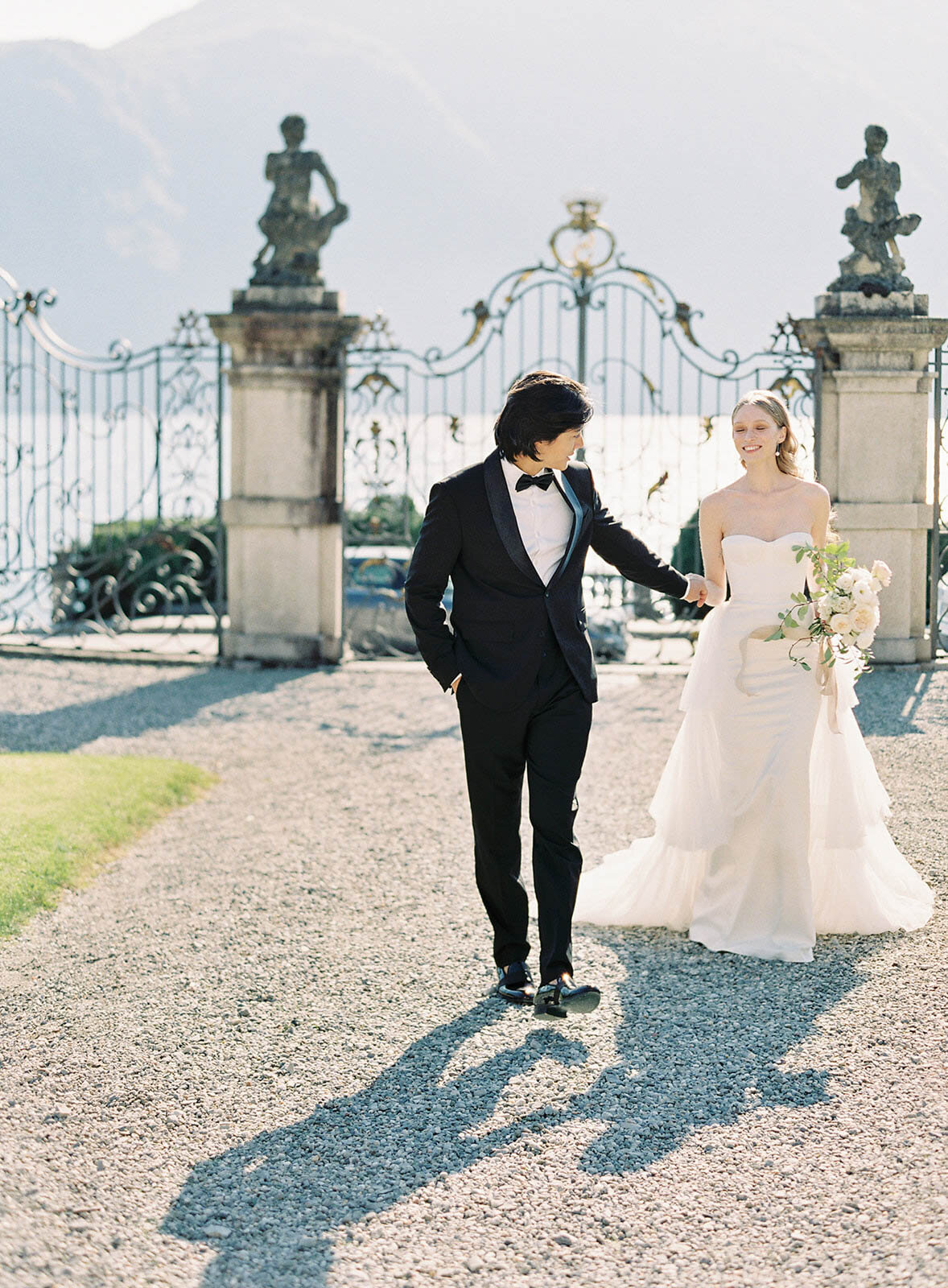 Film photograph of bride and groom walking and holding hands and laughing at their Villa Sola Cabiati Wedding on Lake Como in Italy photographed by Lake Como Wedding photographer