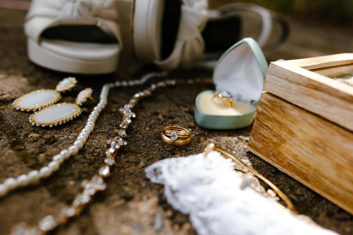 A flat lay of a bride's ring and shoes
