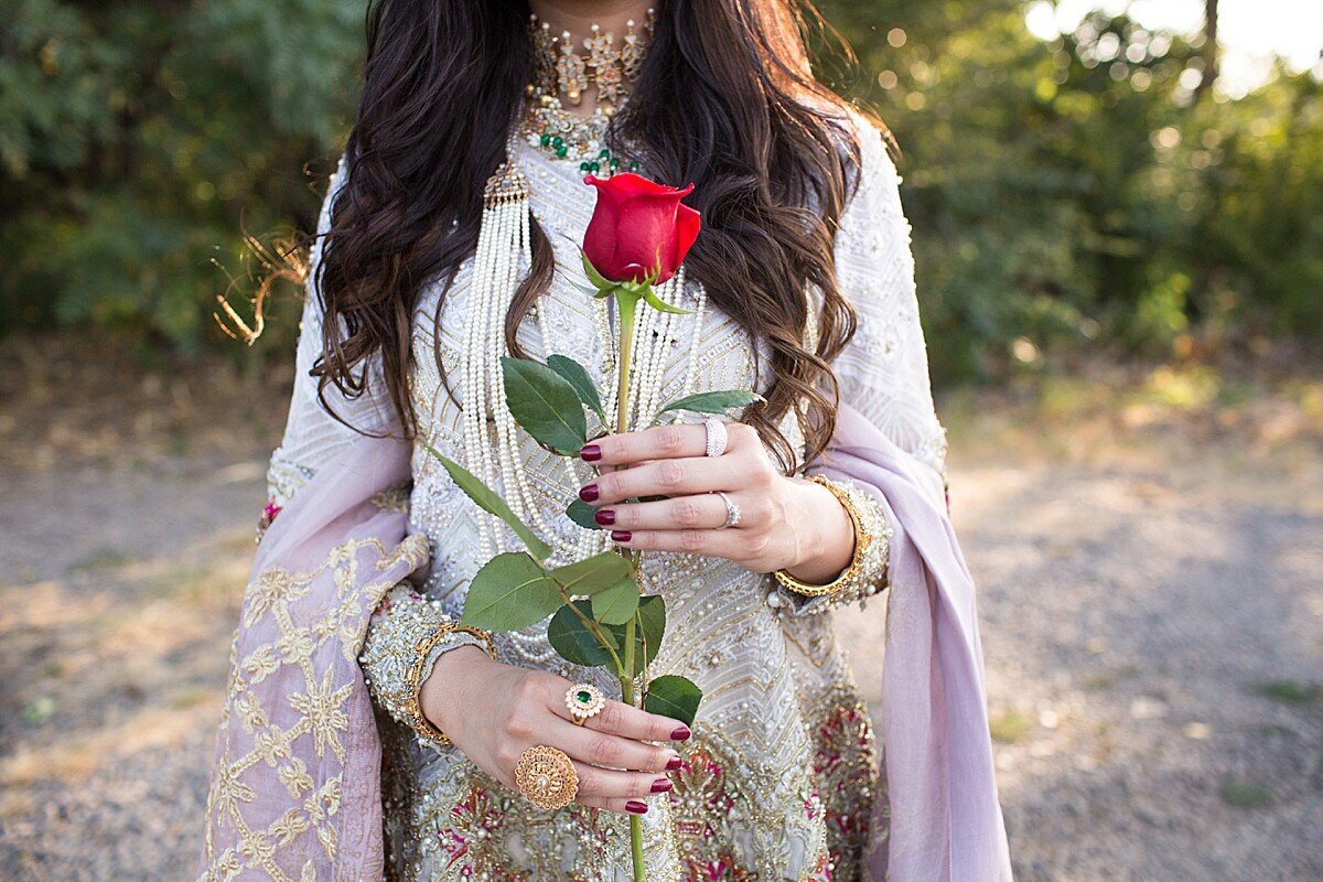 Woman wearing traditional Indian dress and holding a red rose