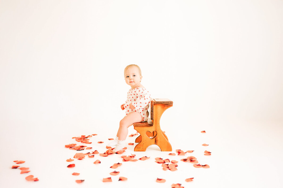 Springfield MO kids photography captures baby girl sitting on stool with roses