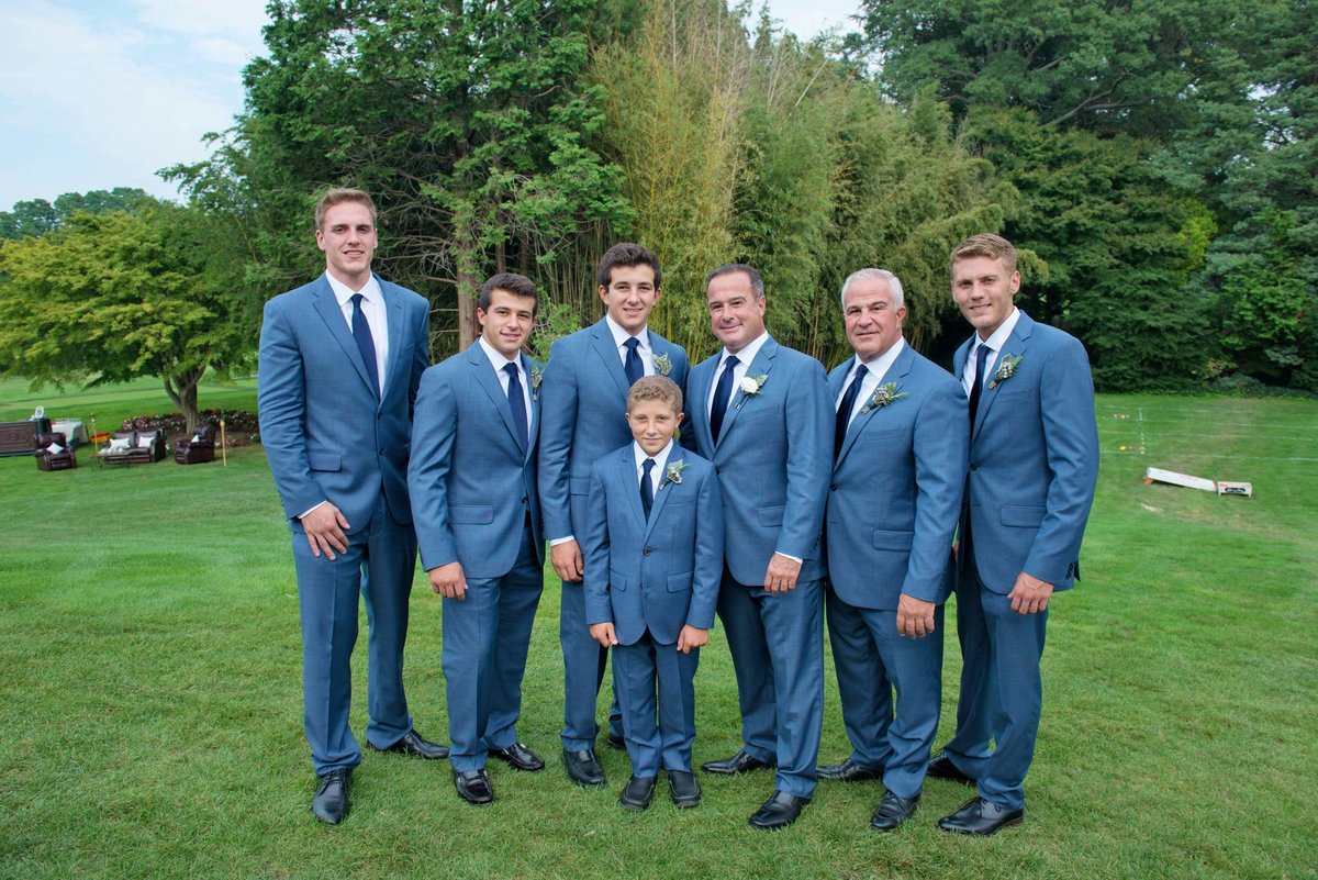 Groom and groomsmen posing outside at Huntington Crescent Club