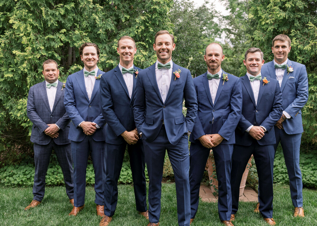 Groom and his friends stand together and pose for the camera before the groom's wedding